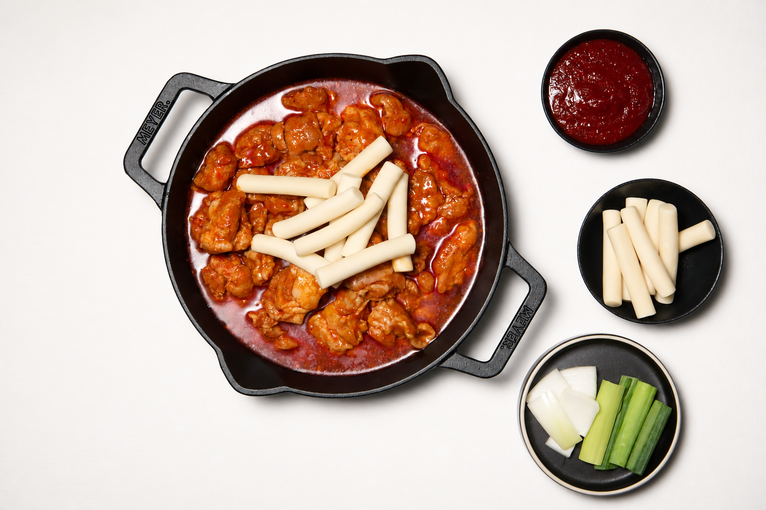 익힌 닭갈비에 떡과 소스를 넣는 모습